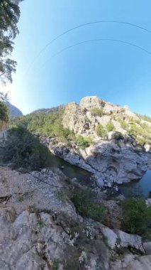 Dikey video. Parlak Mavi Gök Altında Açık Nehir, Dik Uçurumlar ve gür Yeşil Ağaçlar Akan Kayalık Kanyon 'un Geniş Açı Manzarası