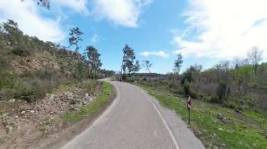 Çamur Yolu 'nun Kavşağı ve Çamurlu Yol Açık Mavi Gökyüzünün Altındaki Ağaçlar ve Ağaçlarla Kayalık Tepeye Gidiyor.