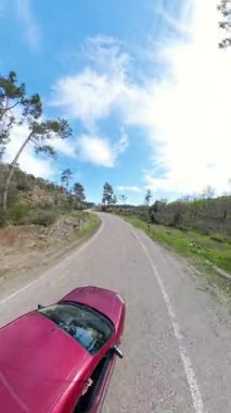 Dikey video. Çamur Yolu 'nun Kavşağı ve Çamurlu Yol Açık Mavi Gökyüzünün Altındaki Ağaçlar ve Ağaçlarla Kayalık Tepeye Gidiyor.