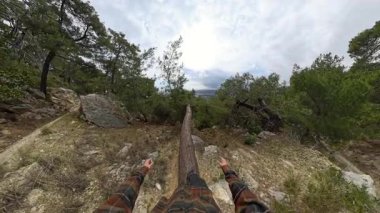 Dar bir ağaçta Dar bir dağ yamacında yürüyen bir adamın ilk insan görüntüsü Bulutlu bir gökyüzünün altındaki uzak bir şehrin manzarasıyla