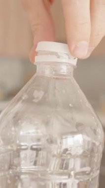Dikey video. Plastik bir şişenin elle açılamayan kapağını kaldırmak, Plastik Kirliliği En aza indirmek için Çevre dostu bir tasarım sergilemek, Yakın plan