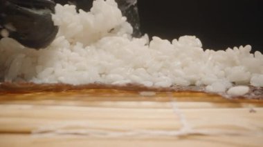 Siyah Eldiven 'i dikkatle teslim et Yapışkan Suşi Pilavını Nori çarşafının üzerine sererken Kamera Mat boyunca Detaylı Makro Çekim yaparken