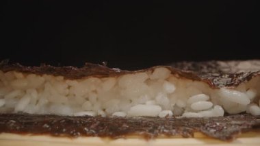 Yakın çekim Makro Suşi Pirinç Sandviçi İki Nori Çarşafı Arasında, Katman Sürecini Düz Kamera Kaydırağıyla Gösterme