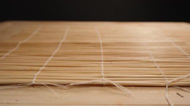 Siyah Eldivenli Eldivenler Bir Nori çarşafını Bambu Mat 'a yerleştirmek, Suşi Pirinç Uygulamasına Hazır olmak, Makro Perspektif Yakalamak
