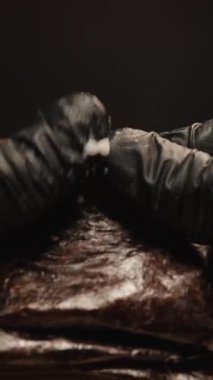 Dikey video. Siyah Eldivenli Eldiven Tutma ve Suşi Yuvarlama, İçindeki Yapışkan Pirinci Ortaya Çıkarma, Dramatik Işıkla Yakın Çekim