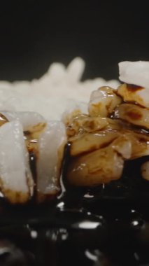 Dikey video. Soya sosu ekstrem Macro Shot 'la Beyaz Pirinç özümsüyor, Taneleri gösteriyor Değişen Renkleri ve Parlak, Lezzetli bir kaplama yaratıyor