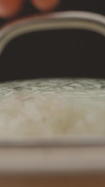 Dikey video. Rising Steam ile taze pişmiş pilavı ortaya çıkarmak için Lid 'i kaldırmak, Yakın çekim Mutfak Sahnesinde Sıcaklığı ve Nemi yakalamak