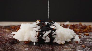 Kalın Soya Sosu Akımı, Beyaz Pirinç 'in üzerine dökülüyor Tahılların üzerine koyu kahverengi bir tabaka oluşturuyor Sıvı Seri Yayılıyor ve Norveç Çarşafına Emiliyor.