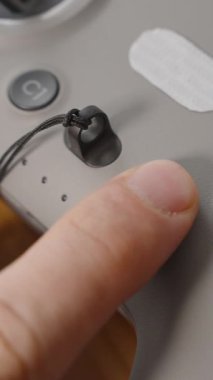 Dikey video. FPV Drone Kontrolündeki Parmak Basma Gücü Düğmesi Bağlı Joystick ve Etkin LED Göstergeleri, Yakın Çekim Macro Görünümü, Başlangıç Konsepti