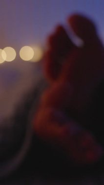 Dikey video. Yatağın altından yükselen kamera Kadın Ayaktan Yüze süzülürken o battaniyenin altında yatarken Akıllı telefon, Ilık ışıklar ve Mavi Renk, İzleme Görüntüsü, Gece Kaydırma Kavramı