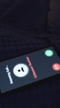Dikey video. Bilge Kadın Gece Yorganın Altında Yatarken Gelen Bilinmeyen Çağrıyı Görüntüleyen Kadın, Yan Görünüm, Gece Bozukluğu Konsepti
