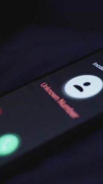 Dikey video. Bilinmeyen Numara 'dan gelen arama, Smartphone Screen' de Mavi Işık, Yakın Çekim Açısı, Gece Karmaşası Konsepti ile Yatakta Dinleniyor