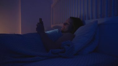 Kadın Yatakta Tarafına Dönüyor ve Uykuya Dalarken Akıllı Telefonu Yatıyor Ekran, Yan Görünüm, Yatma Zamanı Düzenleme Konsepti