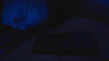 Bilinmeyen Numara 'dan Gelen Arama ile Uyanan ve Telefon Mavi Işık Altında Yatarken Reddeden Kadın, Yan Yakın-Görünüm, Uyku Kesintisi Konsepti