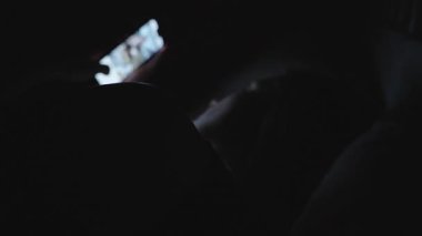 Karanlık Yatak Odasında Yatan Genç Kadın Yüze Yakın Akıllı Telefonu Düşük Işık Açısı, Uykusuzluk veya Gece Kaydırma Konseptinde Parlayan Ekranla Tutuyor
