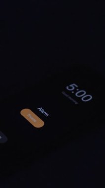 Dikey video. Sabah 5: 00 Uyarısıyla Yatakta Yatan Kadın: Hafif Güneş Işığı Battaniyeyi Aydınlatmaya Başlarken, Erken Başlangıç Konsepti