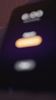 Dikey video. Smartphone Alarm Saat 6 'da Yakından Görüntü Yastık Işığının Altında Yumuşak Sıcak Arkaplan, Aşırı Yakın Çekim Düşük Açı, Erken Teselli Konsepti