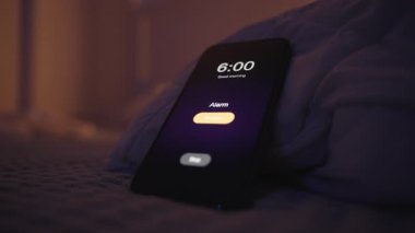 Smartphone 'u Sabah 6' da Çalan Alarmla Açan Kadın, Loş Işıkta Yatakta Uzanıyor, Yakın-Yakın-Düşük Açı, Uykulu Sabah Konsepti