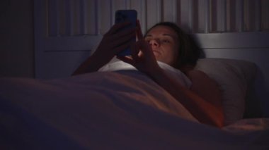 Sim Room, Side View, Digital Wind-Down Konsepti 'nde Uykuya dalmadan Önce Gece Yatağında Uzanan Akıllı Telefon