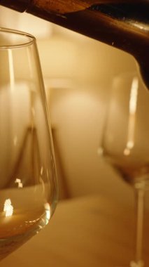 Dikey video. Kırmızı Şarap Bir Bardağa Dolduruluyor Yüzeyde Baloncuklar Oluşturuluyor Sıcak Kapalı Kapılar Işığı Yandan Çekiliyor, Akşam Şımartılması Konsepti