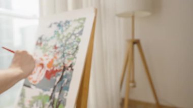 Sanatçı Fırça Dönüşü Yumuşak Işık ve Bulanık Arkaplan, Yan Açı, Yaratıcı Akış Konsepti ile Renkli Ağaç Tuvalinde Boyama Yaparken Pürüzsüz