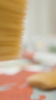 Dikey video. Arka planda Bulanık Boya Kavanozları, Makro Perspektif, Sanatsal Çalışma Alanı Konseptine Odaklanma Giderek Artarak Renkli Tuval Üzerine Uzanan İki Boya Fırçası