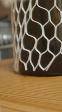 Dikey video. Cam Şişenin Dolly Kaydırma Kapalı Kaplama Beyaz Ağ Koruma Ağı Görünümlü Ahşap Masa Arkaplan Bulanık Mutfak Arkaplan, Hassas Paketleme Kavramı