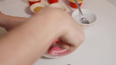 Mutfak tezgahında Kap Kekleri 'nin yanında Eller Harmanlanırken Beyaz Kasede Girdap Pembesi Dondurması, Masaüstü Görünümü, Tatlı Dekorasyonu Konsepti