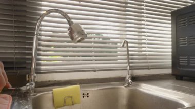 Arka plandaki güneşlikler, Göz Seviyesi Açısı, Su Aracı Konsepti, Su Tedarik Konsepti ve Güneş Işığıyla Su Akışı Gösterilmesin diye Esnek Musluk Musluğu 'na El Tıklatma