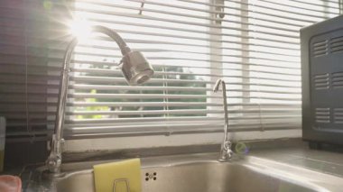 Son Gün Işıkları Esnek Musluğa Yansıtırken Mutfak Penceresinin Kapanması ve Karanlık Yerleşmeden Önce Batması, Göz Seviyesi Açısı, Gece Kavramına Geçiş