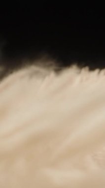 Dikey video. Makro Kaydırıcı Yumuşak Krem Fiberler Arasında Hareket Ederken Sığ Odaklanma ve Yumuşak Akış Koyu Bir Konsept Kumaş Hareketi ve Doğal Hareket Üzerinde