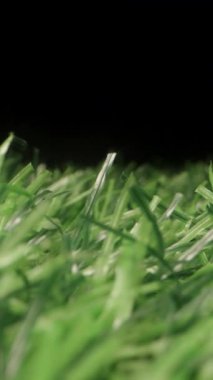 Dikey video. Bıçak Detayı ve Derinlik Odaklanarak Yapay Yeşil Çimenler Arasında Yapay Yeşil Çekim Temiz Bir Gece Sahnesi Efekti Yaratılıyor Sentetik Doğa ve Asgari Gece Estetiği