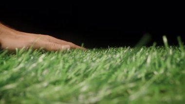 Koyu Arkaplan Dokunuşu ve Sentetik Doğa Konseptine Karşı Görünür Temas ve Dokunsal Etkileşim Sağlayan Yapay Yeşil Çimenin Yakın Çekimi