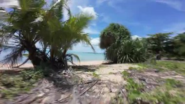 FPV İnsansız Hava Aracı, Sandy Tropikal Plajı 'nda, Arkaplanda Okyanus ve Ada Keşfi Açısında Açık Mavi Gökyüzü' nde Uçuyor.