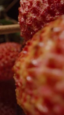 Yeşil Yapraklı Yansıtıcı Yüzeye Parlak Kırmızı Lychees ve Yumuşak Işık Altında Woody Stems 'in Dolly Kaydırma Çekimi
