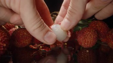 Tohum ve Pulp ile el ele tutuşan Lychee 'yi Parlak Yüzeye yerleştirirken Tam Meyveler ve Yapraklar Arkaplanda Stüdyo Işığıyla Yakından Yakından Çekildi