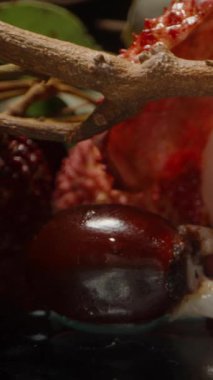 Yumuşak Işık Altında Yansıtıcı Yüzeye Yansıtıcı Meyveler Dağılmış Dolly Kaydırıcı Elle Kapalı Lychee Tohumu Kabukları ve Tüm Meyvelerle Dağıtılıyor