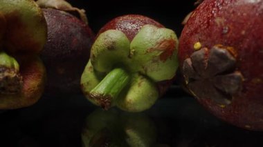 Dolly Kaydırıcı Tüm Mangosteen Meyvelerinin İçinden Yeşil Başlıklar ve Stüdyo Kurulumundaki Yansıtıcı Yüzeyde Kırmızı Mor Derilerle Yakın Çekim