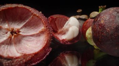 Split Mangosteen 'in Dolly Kaydırıcı Kapanışı Sulu Beyaz Segmentleri ve Derin Kırmızı İç Kabuğu Yansıtıcı Yüzeyde Tüm Meyvelerle Gösteriyor