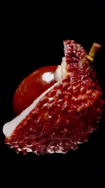 Lychee, Sulu Beyaz Et ve Siyah Fonda Kırmızı Dikenli Kabuk, Çiğ Tropikal Meyve Konsepti ile Kusursuz Döngüde Dönüyor