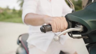 Beyaz gömlek, yan makro görüş, ivme ve motor başlatma kavramı giyerken Erkek Elinin Yakın Çekimi Scooter 'ın Gazına Basma Kavramı