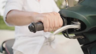 Beyaz Gömlekli Adam ve Kısa Şortlu Adam Yeşil Moped 'de Palmiye Ağacı Asılı Beton Yolu' nda, Hareket Bulanıklığıyla Arka Görüş, Geç Öğlen Işığı, Tropikal Seyahat Konsepti