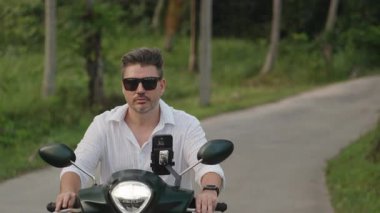 Beyaz Gömlekli Adam, Orman Yolu 'nda sürerken Scooter' da Kameradan Geçiyor, Yavaş Çekimde Sağ Tarafa Bakış, Tropikal Sollama Konsepti