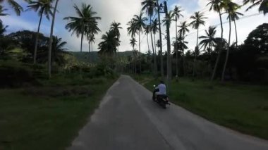 Falsolu Beton Yolu 'nda Scooter süren adam İHA' nın yetiştiği ve geçtiği yerde, Arka Hava Hareketi Çekimi, Tropikal Takip Konsepti