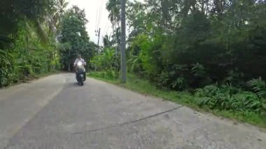 Motosikletli Adam, Muz Ağaçları, Ön Yer Düzey Açısı, Orman Keşfi ile Yoğun Tropikal Bölgede Kameraya Doğru Sürüyor