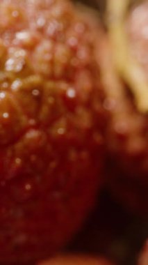 Dikey video. Islak Olgun Lychees 'in Aşırı Kapanışı Dolly Kaydırma Hareketiyle Ayrıntılı Doku ve Nemli Yüzey Altında Siyah Arkaplanda Sığ ve Sığ Derinlik