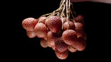 Güçlü Karşıtlık ve Görünür Gölgeler Sabit Stüdyo Kurulumunda Siyah Arkaplan Karşısında Sert Işığın Altında Olgun Lychees Kümesi