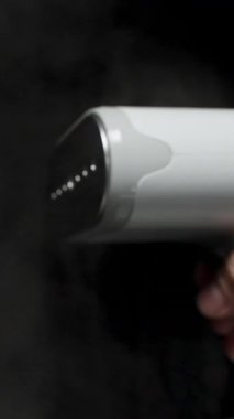 Dikey video. Bir Stüdyo Ayarında Görünür Bulut ve Bulanık Arkaplanlı Siyah Kumaşa Yavaş Çekimde Buharlı Buharlı Geniş Açı Görünümü