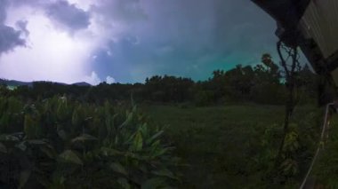 Tropikal Yağmur, Zaman Hızı Hareketi sırasında Bulutların Arkasından Ay 'ın yükseldiği Gece Adası manzarası Karanlık Gök ve Yoğun Orman Yapraklarını Yakalıyor