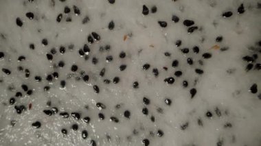 Dönen ve Düşen Ejder Meyvesinin Dolly Kaydırıcısının Yakın Çekimi Siyah Arkaplana Karşı Havada Siyah Tohumlar ve Parlak Pembe Deriyle Beyaz Etleri Gösteriyor